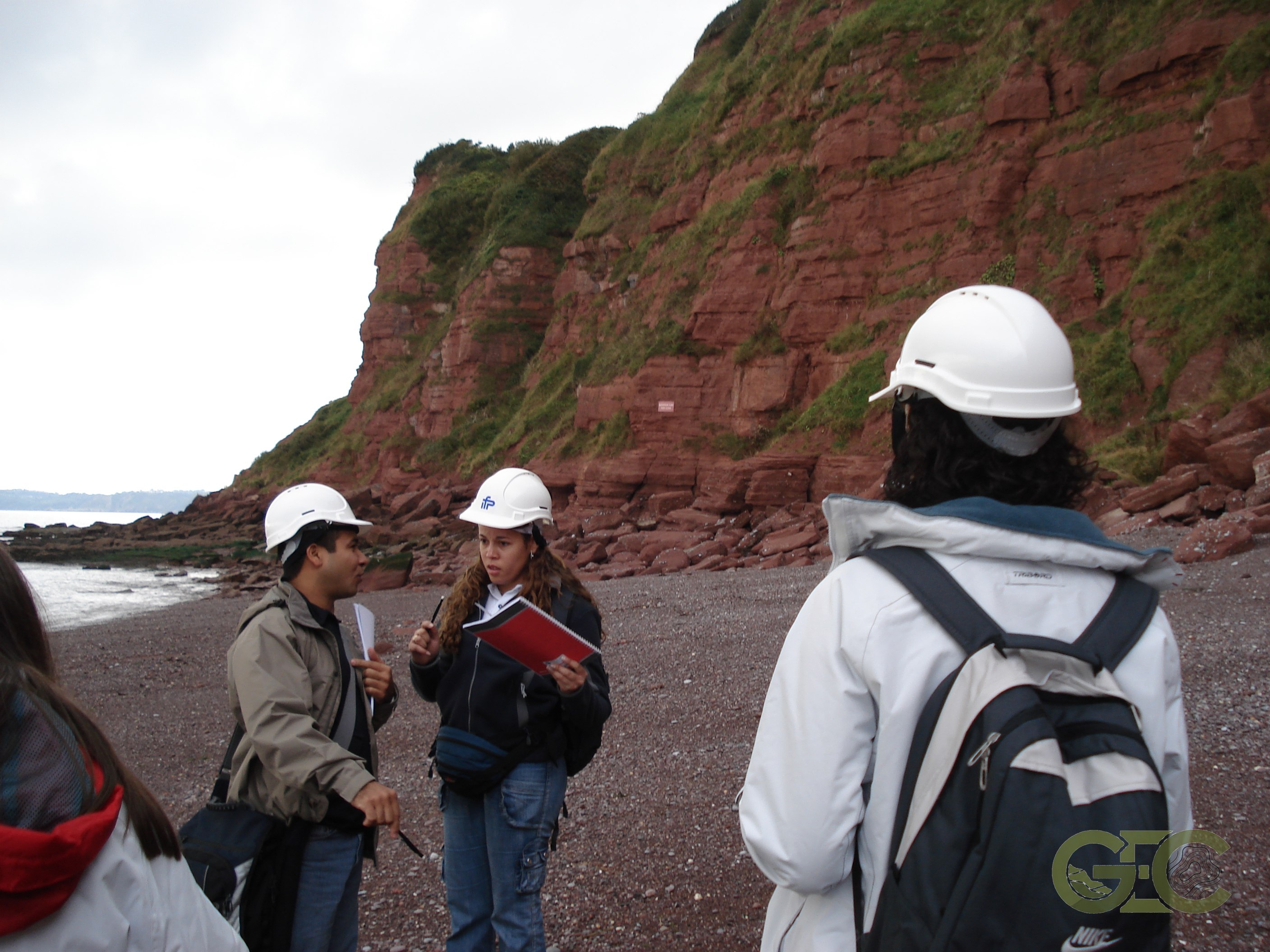 Geology field trip team examining coastal cliff strata
